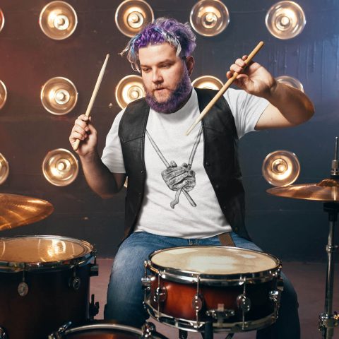 Maglietta unisex bacchette dure mani dure bianca e un batterista maschio con capelli viola sul palco