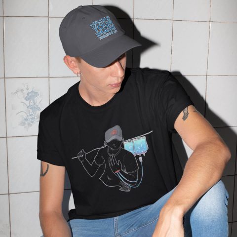 Maglietta unisex musicoterapia endovenosa nera e giovane uomo moderno in posa con una maglietta e un cappello